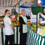 FIVE-A-DAY... the new fruit and vegetables stall outside George Eliot Hospital receives plenty of attention as staff get served by (right) chief executive Kevin McGee watched on by Paul Lancaster of the Barrow Boys Grocers 