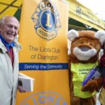 Darlington Lions Club member Robert Hillary, bookshop chairman dressed in a lion costume with Tom Peacock and Jenny Lumley at a previous charity market stall book sale